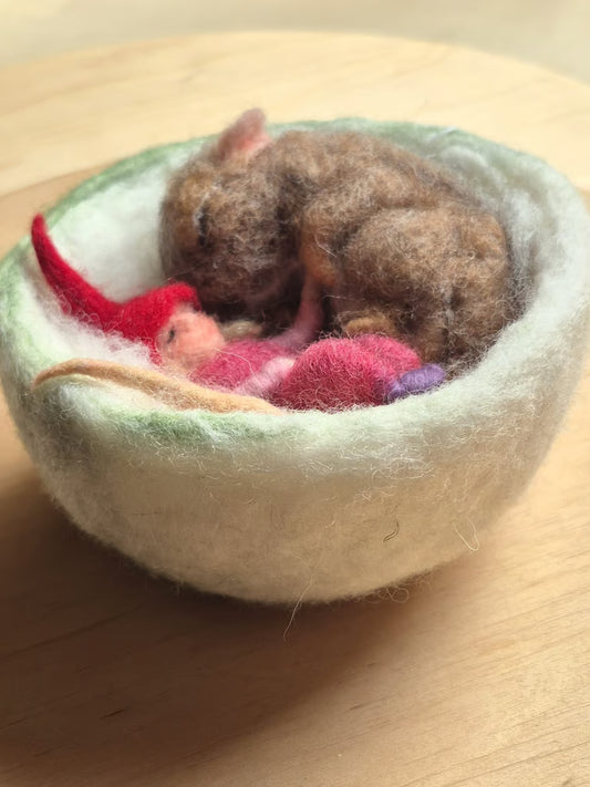 Slapend muisje met roze kaboutermeisje in wollen mandje