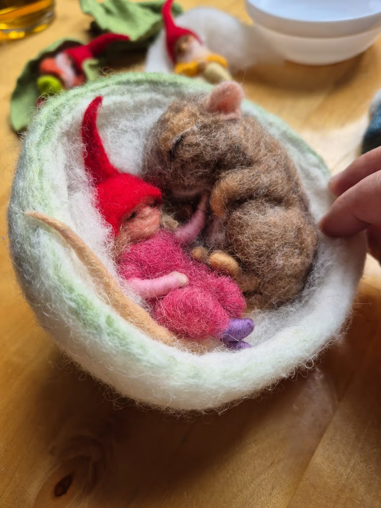 Schlafende Maus mit rosa Gnomenmädchen in einem Wollkorb